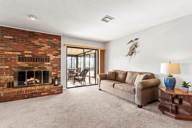 living room with carpet, visible vents, a fireplace, and a textured ceiling