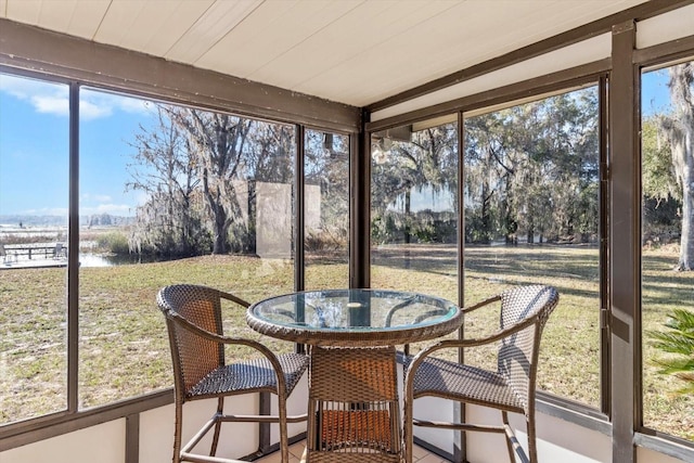 sunroom featuring wooden ceiling and a water view