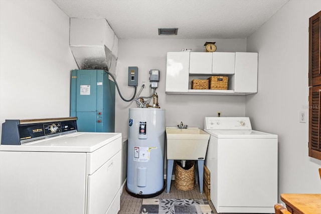 clothes washing area featuring cabinet space, visible vents, washing machine and dryer, electric water heater, and a textured ceiling