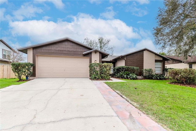 view of front of house with driveway, a garage, a front lawn, and stucco siding