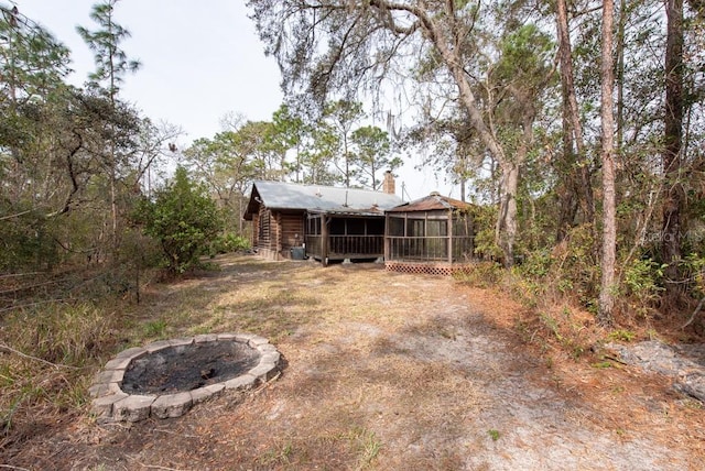 view of yard with a fire pit and a sunroom