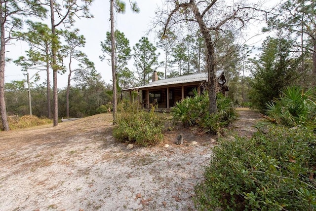 exterior space featuring metal roof and a chimney