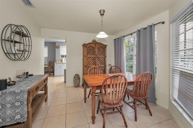 dining space with light tile patterned floors, visible vents, and baseboards