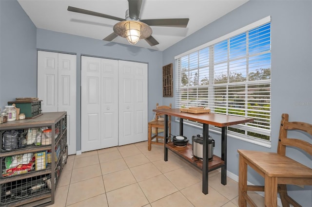 interior space featuring light tile patterned floors, baseboards, and a ceiling fan