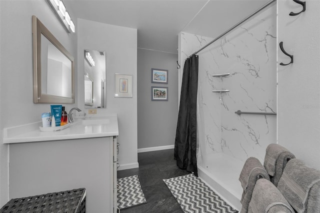 full bathroom featuring a stall shower, vanity, and baseboards