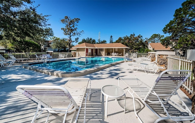 pool with a patio area and fence