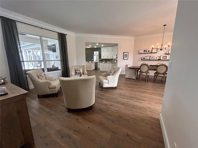 living room featuring baseboards, ornamental molding, dark wood-style flooring, and a notable chandelier