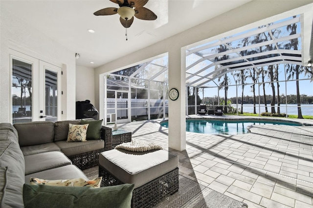 view of pool featuring a water view, ceiling fan, and a fenced in pool