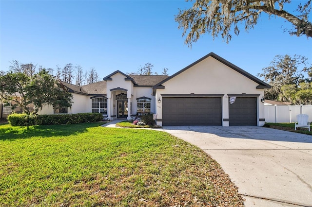 view of front of home with stucco siding, driveway, fence, a front yard, and an attached garage