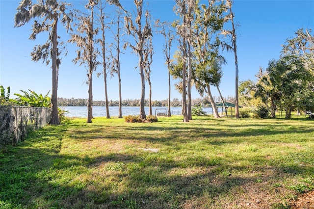 view of yard featuring fence and a water view