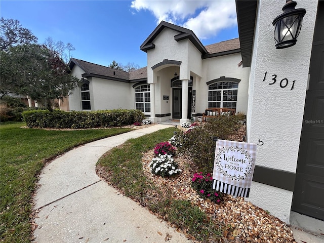 1301 Jen Ma Jo Ln, Lutz, FL 33549 - view of front of property with stucco siding, a front lawn, and a shingled roof