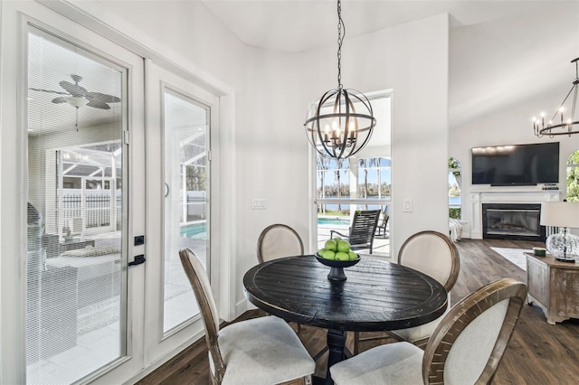 1301 Jen Ma Jo Ln, Lutz, FL 33549 - dining area featuring a chandelier, dark wood-style flooring, a glass covered fireplace, and vaulted ceiling