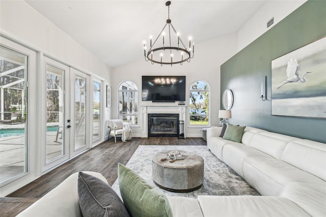 1301 Jen Ma Jo Ln, Lutz, FL 33549 - living area with french doors, a chandelier, dark wood-style floors, a glass covered fireplace, and lofted ceiling