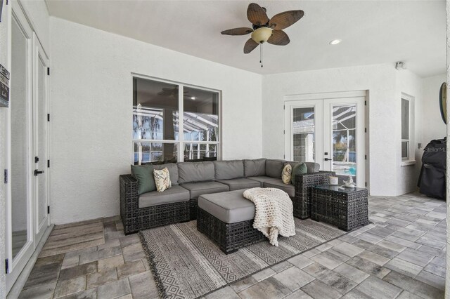 1301 Jen Ma Jo Ln, Lutz, FL 33549 - living room featuring french doors, a ceiling fan, stone finish floors, and plenty of natural light