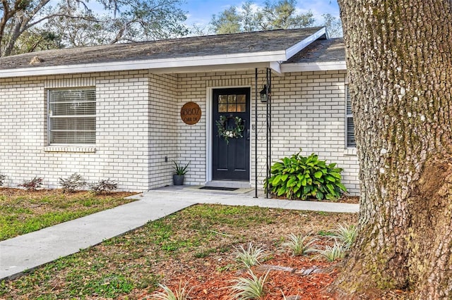 property entrance featuring brick siding