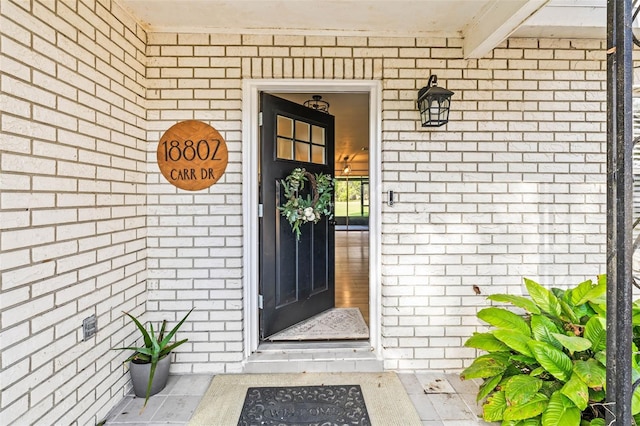 doorway to property with brick siding