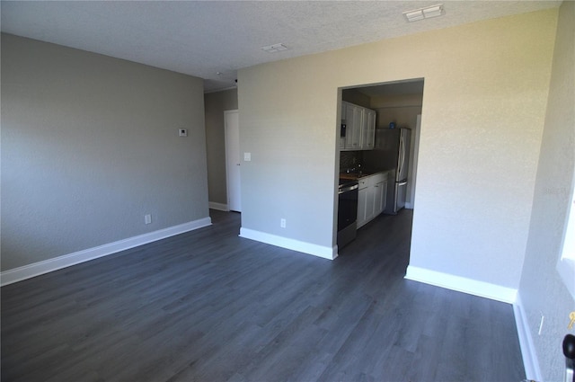 unfurnished room featuring a textured ceiling, dark wood finished floors, visible vents, and baseboards