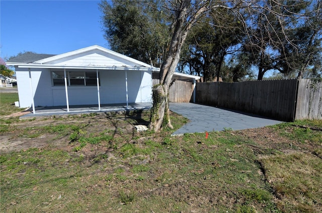 exterior space featuring concrete block siding and fence