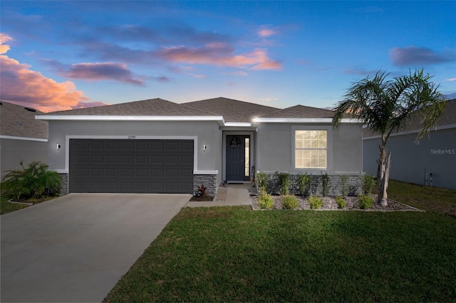 ranch-style house featuring a front lawn, stone siding, an attached garage, and stucco siding