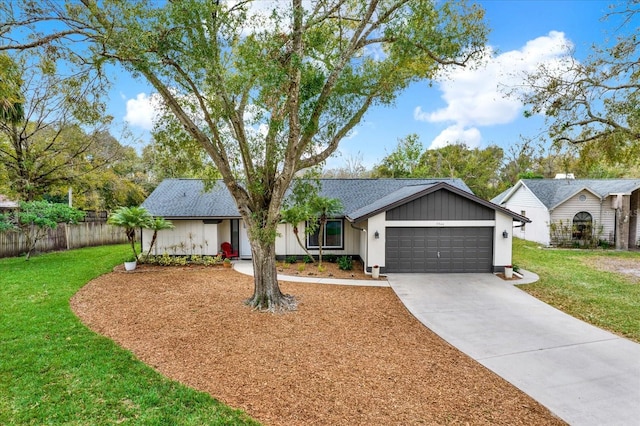 ranch-style home with driveway, a front lawn, an attached garage, and fence