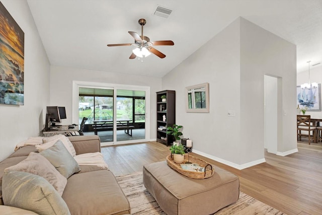 living room with high vaulted ceiling, ceiling fan with notable chandelier, visible vents, baseboards, and light wood-type flooring