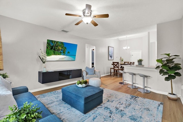 living area featuring visible vents, baseboards, and wood finished floors