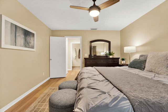 bedroom with ceiling fan, light wood finished floors, visible vents, and baseboards