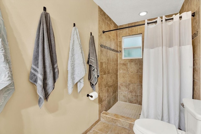 bathroom featuring a tile shower, toilet, and tile patterned floors