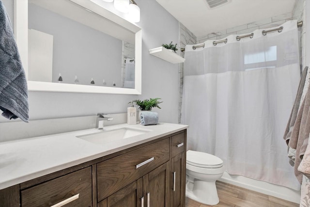 bathroom with visible vents, toilet, wood finished floors, shower / bath combination with curtain, and vanity