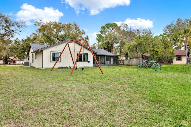 back of property featuring a yard, central AC unit, and fence