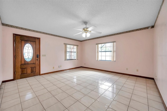 foyer featuring light tile patterned floors, baseboards, a ceiling fan, and a textured ceiling