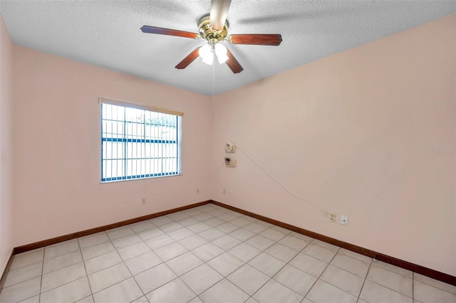 unfurnished room with a textured ceiling, ceiling fan, and baseboards