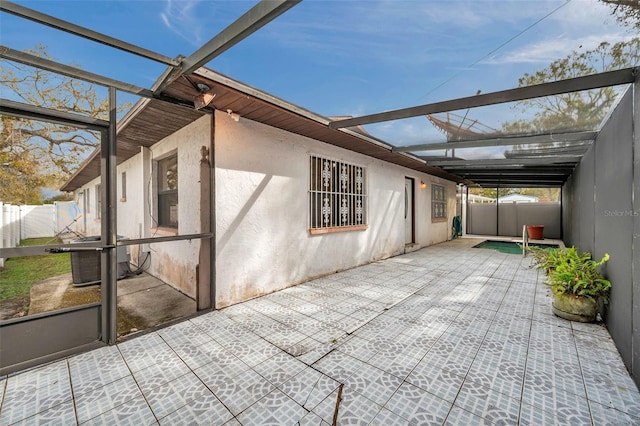 exterior space featuring central air condition unit, a patio area, fence, and stucco siding