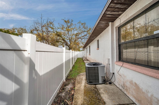 view of home's exterior with a fenced backyard, cooling unit, and stucco siding