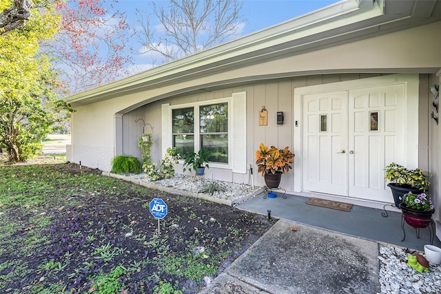 view of exterior entry with covered porch and brick siding