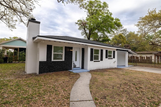 single story home with a front lawn, a chimney, fence, and stucco siding