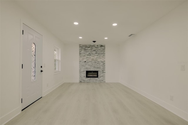 unfurnished living room featuring a fireplace, recessed lighting, visible vents, light wood-style flooring, and baseboards