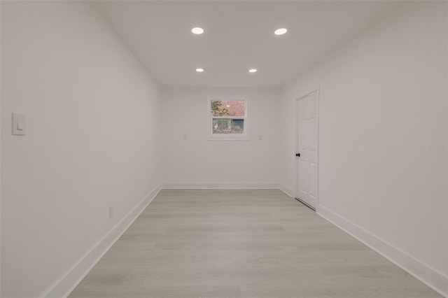 spare room featuring light wood-type flooring, recessed lighting, and baseboards