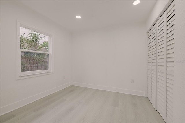 spare room with recessed lighting, light wood finished floors, and baseboards