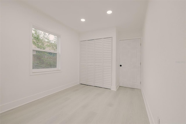 unfurnished bedroom featuring light wood-style floors, recessed lighting, a closet, and baseboards