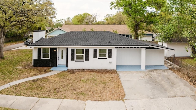 ranch-style home featuring a shingled roof and a front yard