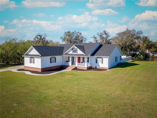 ranch-style home featuring covered porch and a front yard