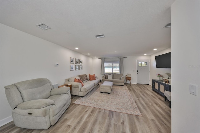 6333 Spanish Main Dr, Apollo Beach, FL 33572 - living area with a textured ceiling, light wood finished floors, and visible vents