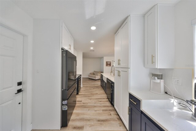 6333 Spanish Main Dr, Apollo Beach, FL 33572 - kitchen featuring light wood-type flooring, freestanding refrigerator, white cabinetry, and recessed lighting