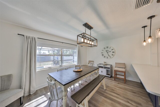 6333 Spanish Main Dr, Apollo Beach, FL 33572 - dining room featuring a textured ceiling, wood finished floors, visible vents, and baseboards