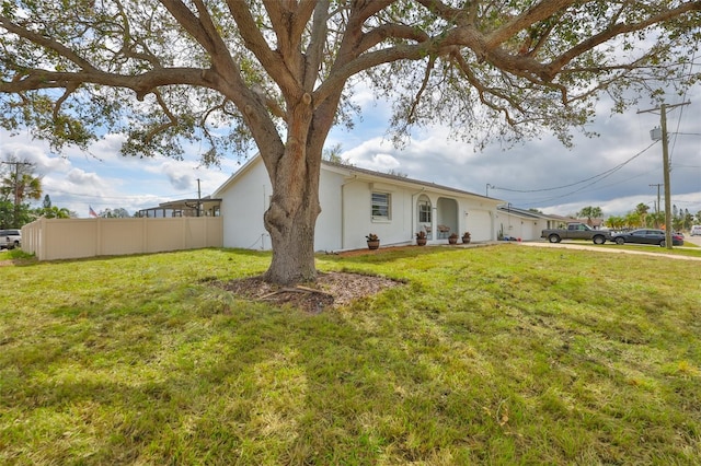 6333 Spanish Main Dr, Apollo Beach, FL 33572 - exterior space with an attached garage, fence, a front lawn, and stucco siding