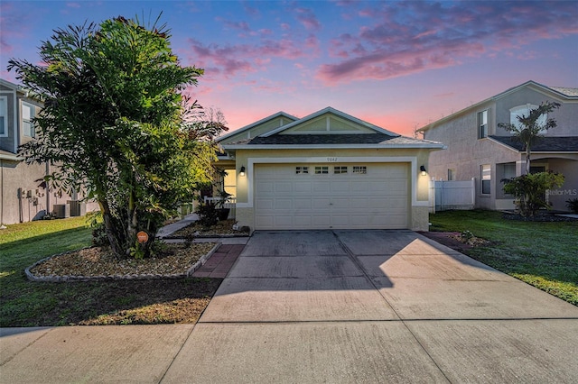 view of front facade featuring driveway, a yard, a garage, and stucco siding