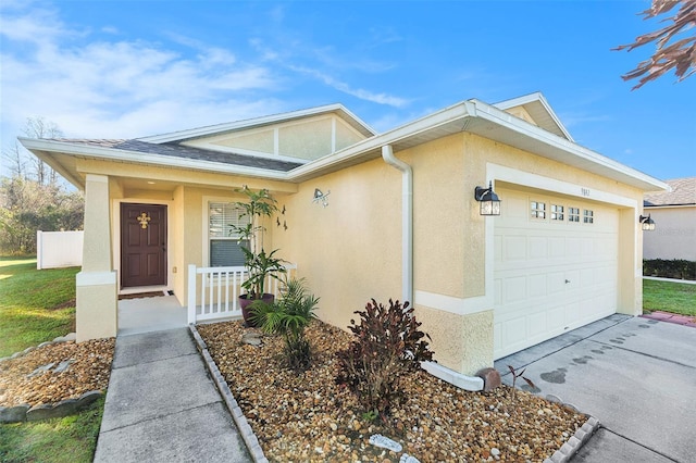 view of front of house featuring a garage, driveway, and stucco siding