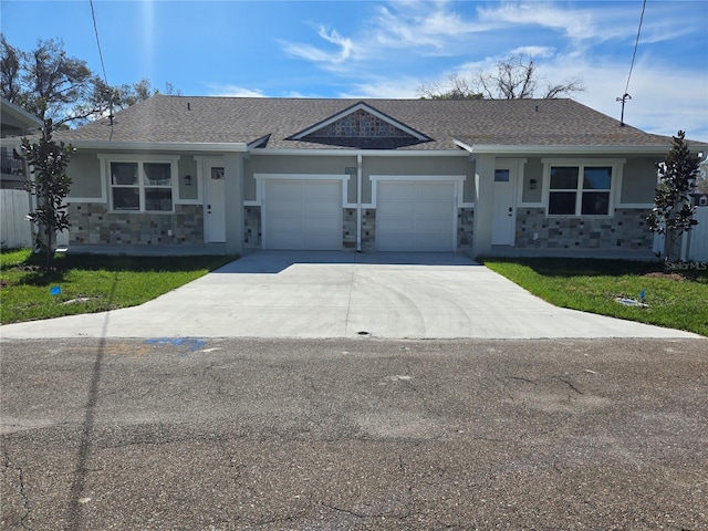 single story home with an attached garage, a shingled roof, stone siding, concrete driveway, and stucco siding