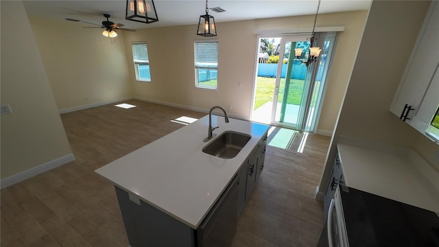 kitchen featuring a sink, visible vents, open floor plan, hanging light fixtures, and dark wood finished floors